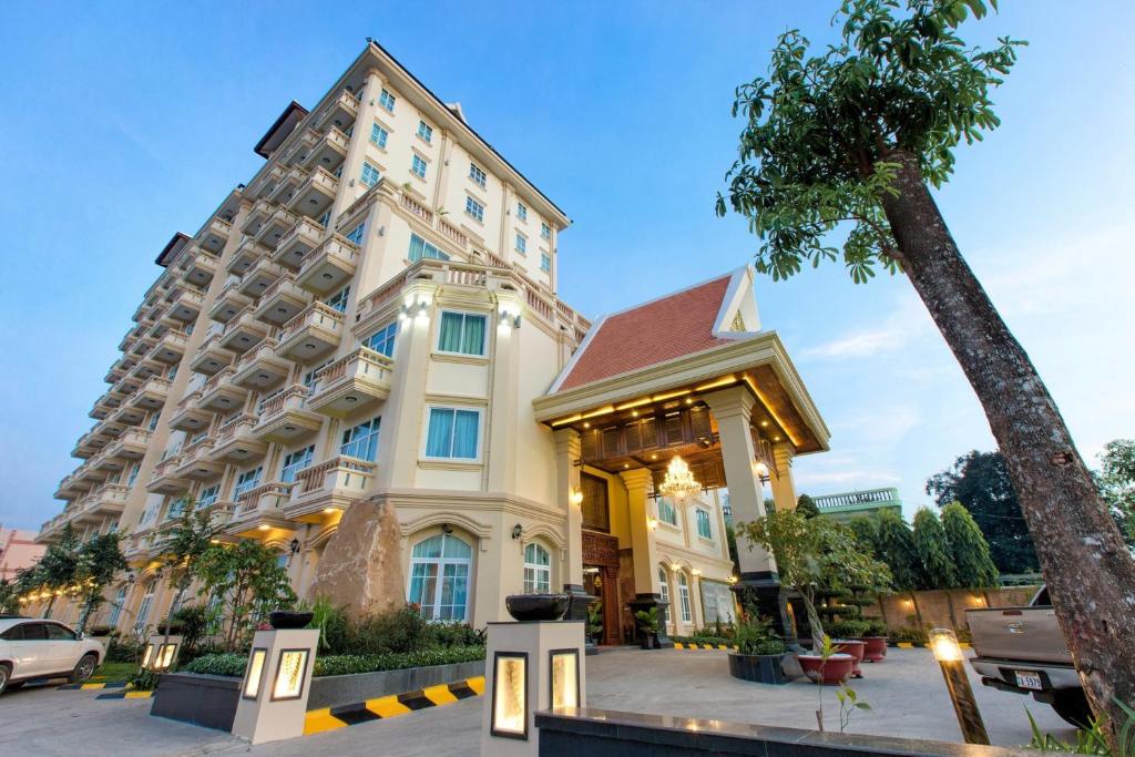 马德望优雅酒店的一座大建筑,前面有棕榈树