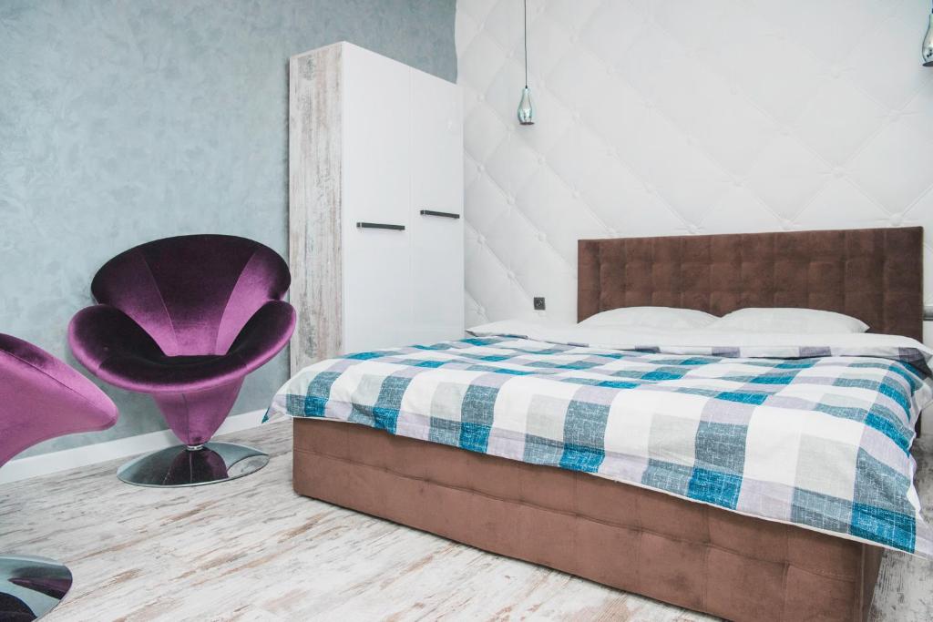 利沃夫Апартаменти в центрі Львова的一间卧室配有一张床和一张紫色椅子