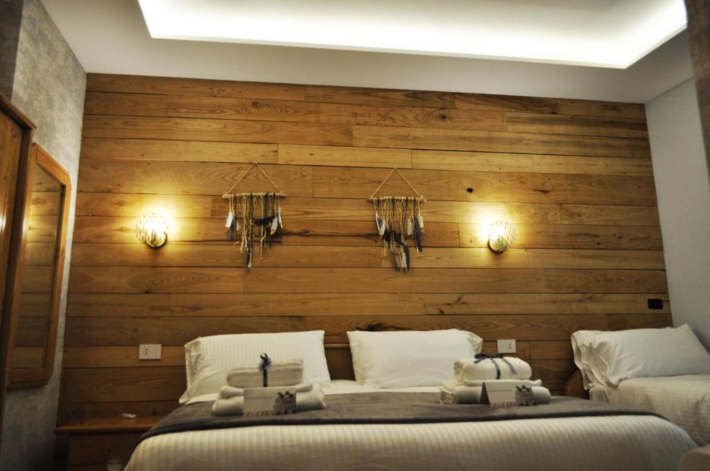 卡迈格拉特罗希拉诺Epoca in Sila的一间卧室设有木墙和床