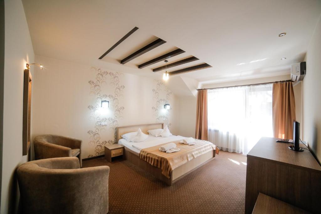 伯伊莱海尔库拉内Pensiunea JOJO的酒店客房配有一张床、一张书桌和一台电视。