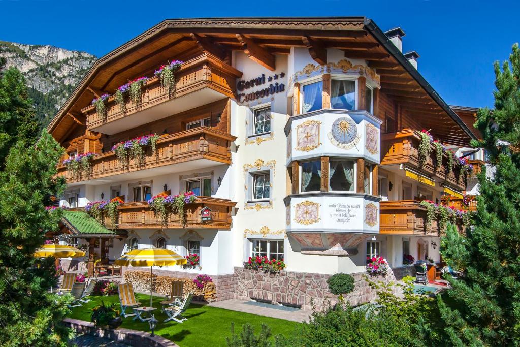 塞尔瓦迪加尔代纳山谷Hotel Garni Concordia - Dolomites Home的山上的酒店,阳台上种着鲜花