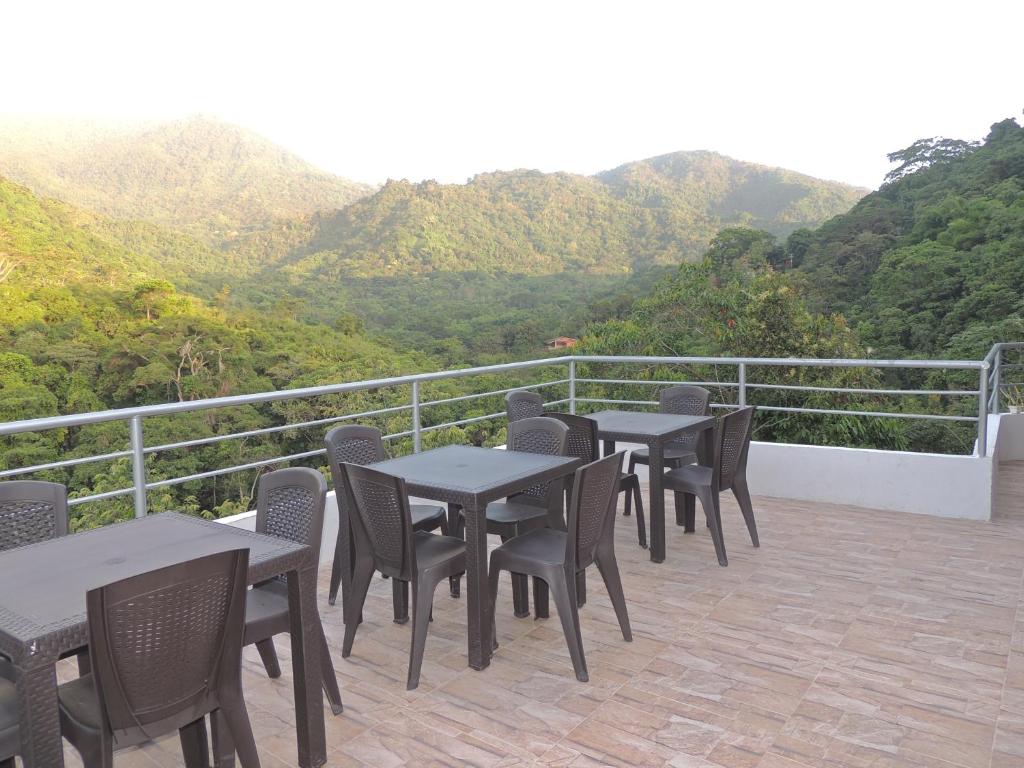 米卡Hostal Alto de la Montaña的一组桌椅,位于一个享有山景的阳台