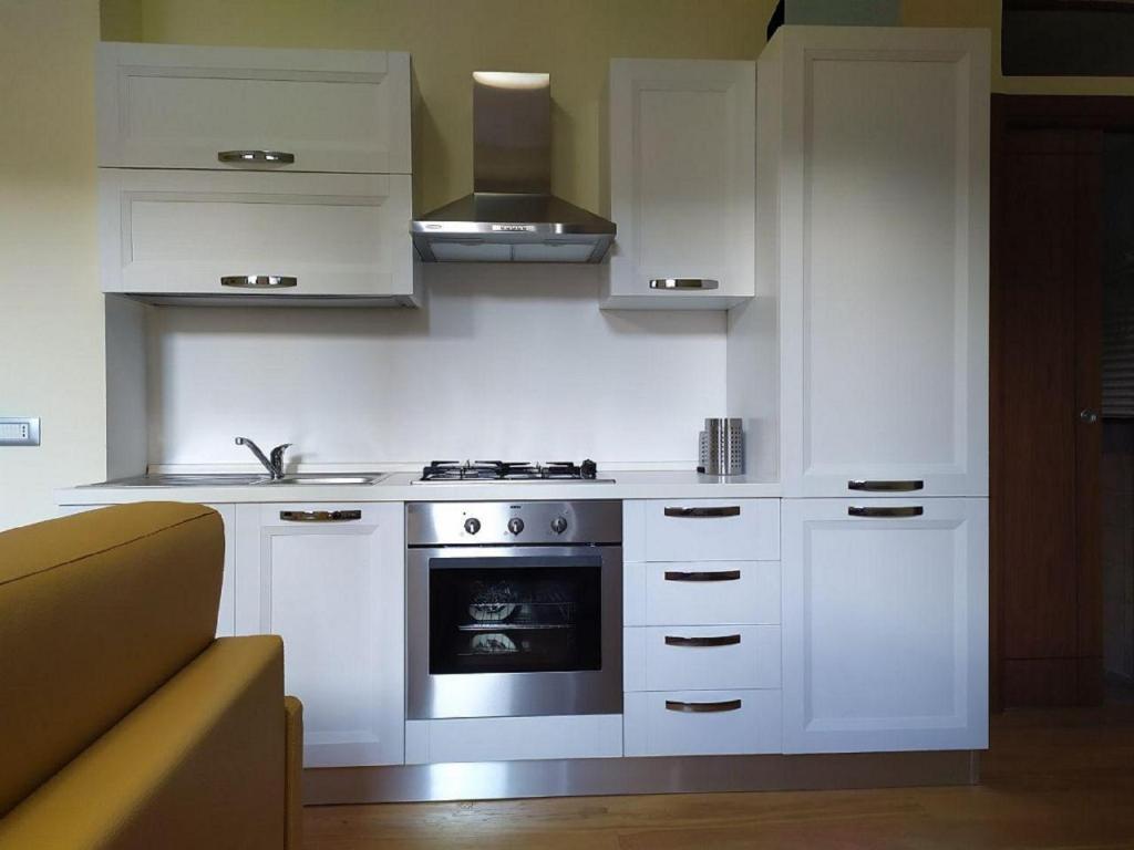 利维松多里FORT. Montagna A305的厨房配有白色橱柜和炉灶。