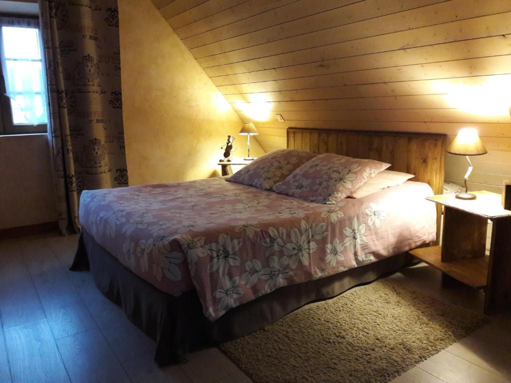 Langensoultzbach普尤特住宿加早餐旅馆的卧室配有一张床铺,位于带木墙的房间内