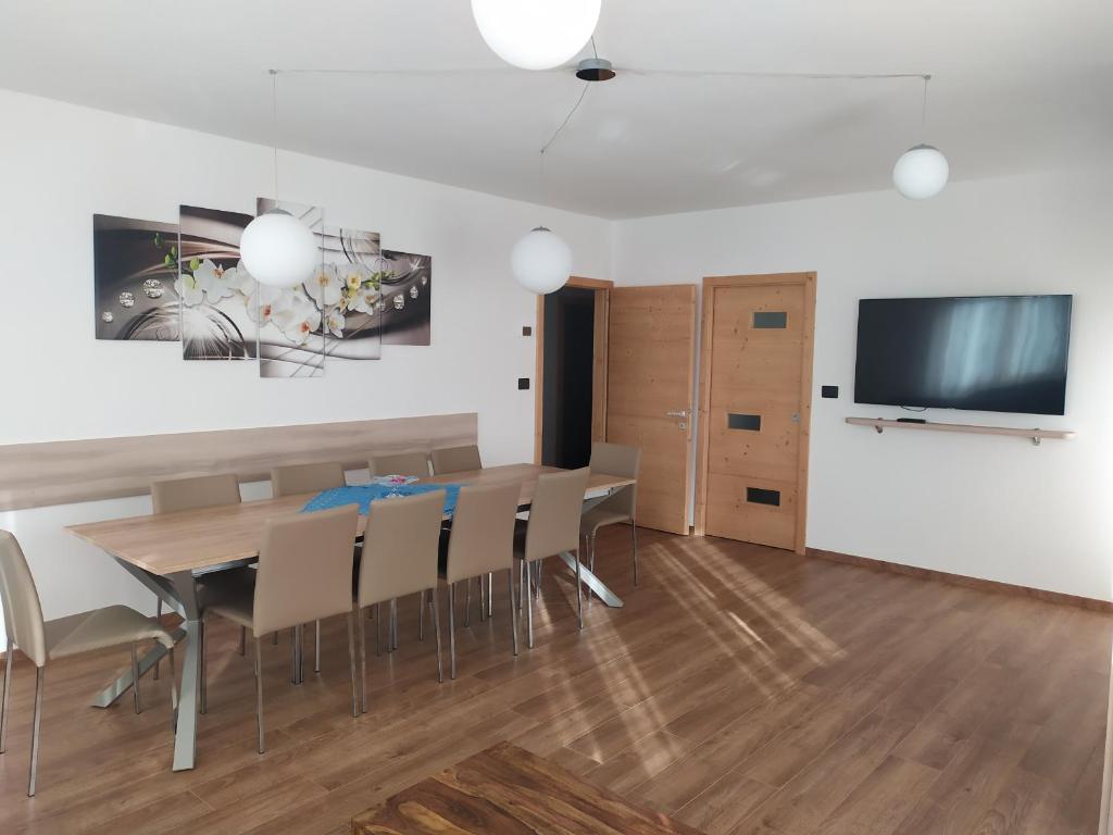 帕苏德尔托纳莱Appartamento DIAMANTE的用餐室配有桌椅和平面电视。