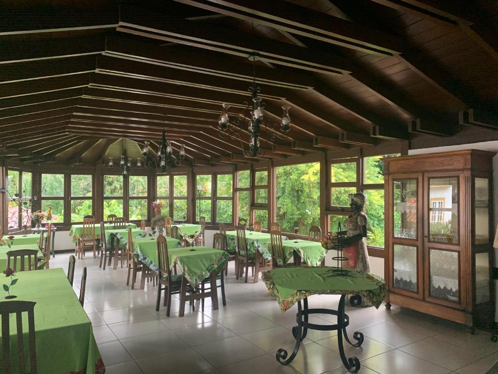 蒂拉登特斯瑞尔别墅旅馆的用餐室配有绿色的桌椅