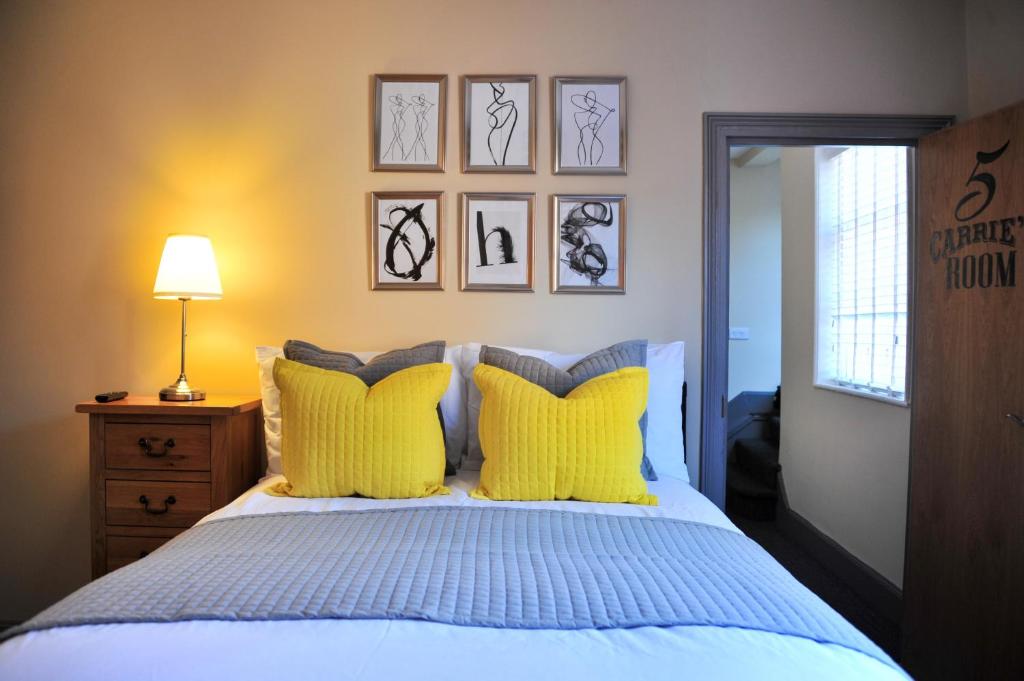 雷特福德The Herbalist Rooms的一间卧室配有一张带黄色枕头的床