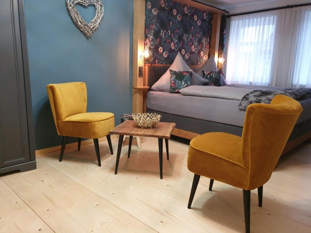 巴特索登-阿伦多夫Pelikans Krone的一间卧室配有一张床、两把椅子和一张桌子