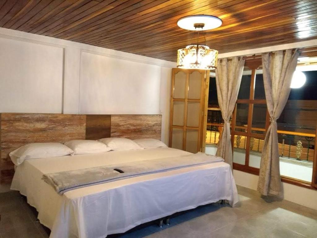 圣罗莎德卡瓦尔CIELITO LINDO的一间卧室设有一张带木制天花板的大床