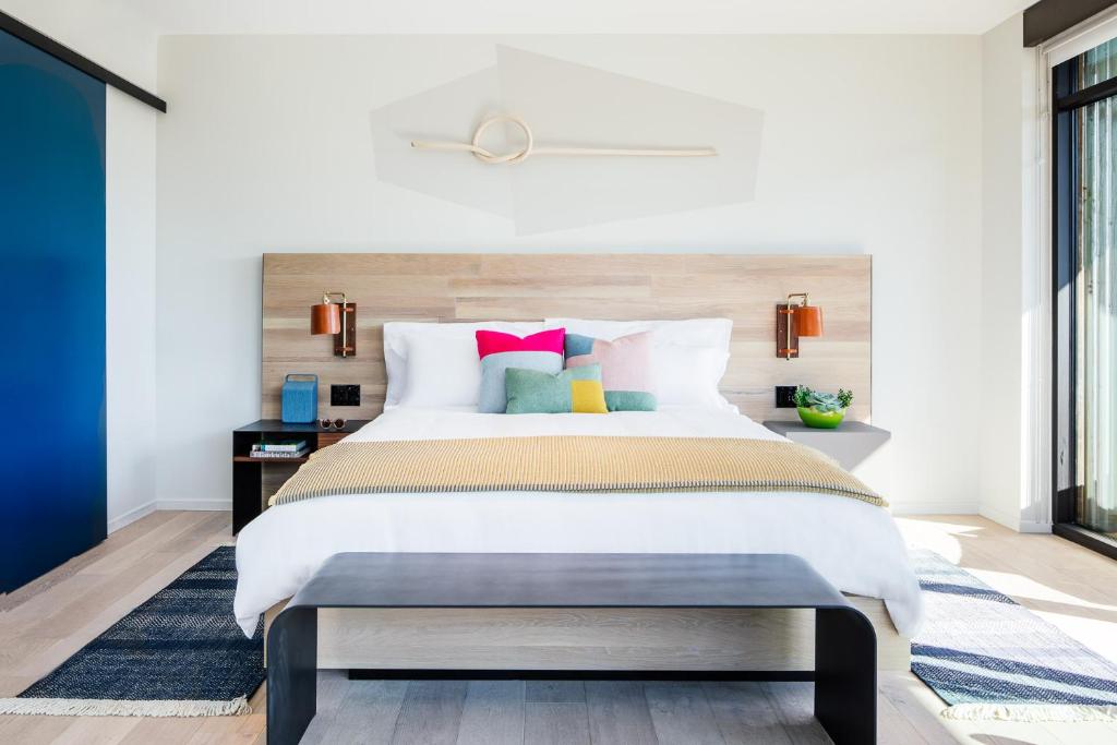圣路易斯-奥比斯保Hotel San Luis Obispo的一间卧室配有一张带色彩缤纷枕头的大床