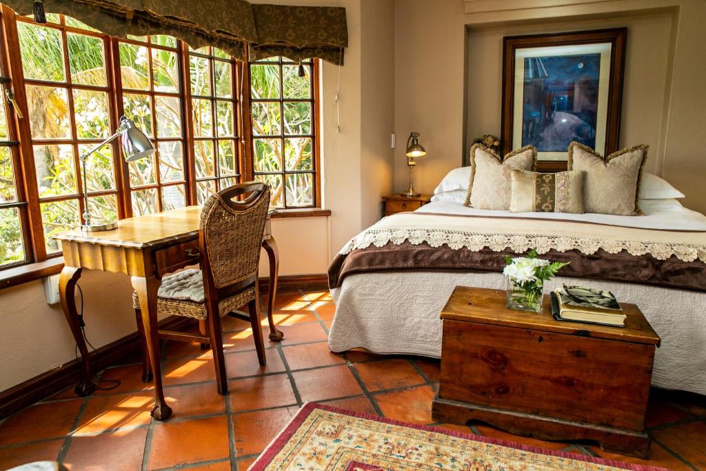 勒斯滕堡Terra Casa Guesthouse的卧室配有一张床、一张书桌和窗户。