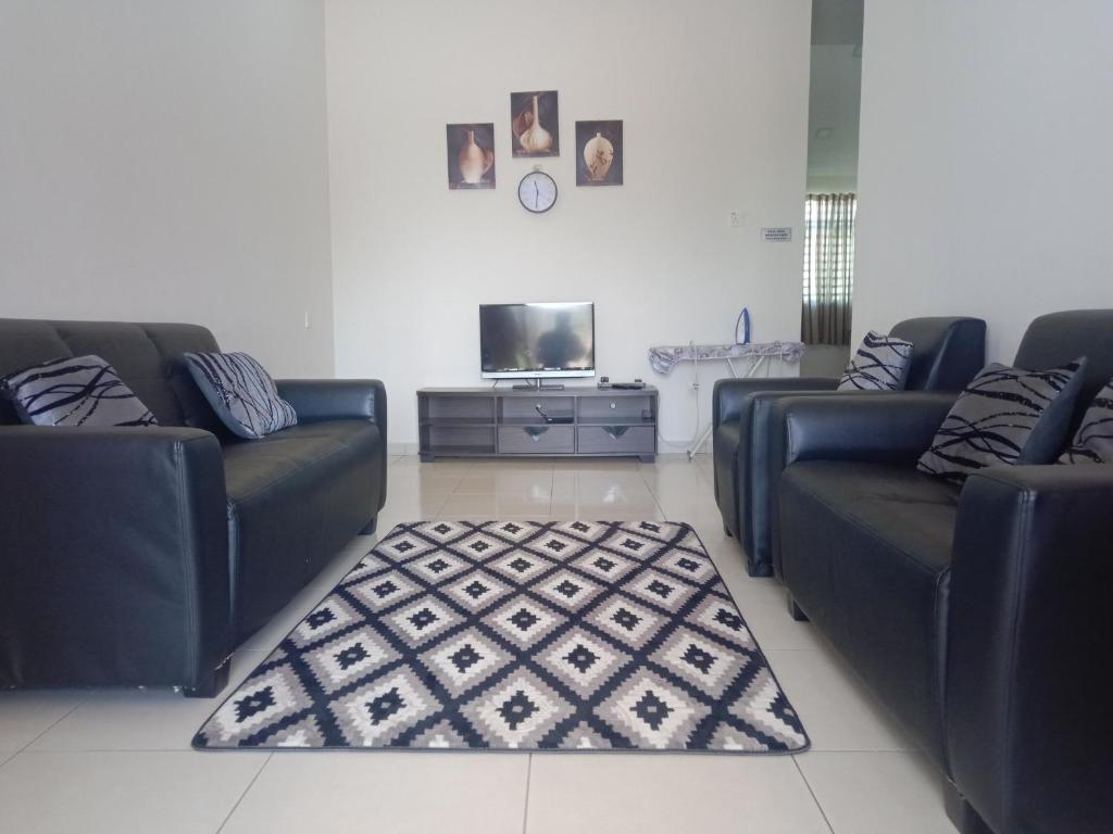 阿罗士打亚罗士打哈兹民宿的客厅配有两张沙发和一台电视