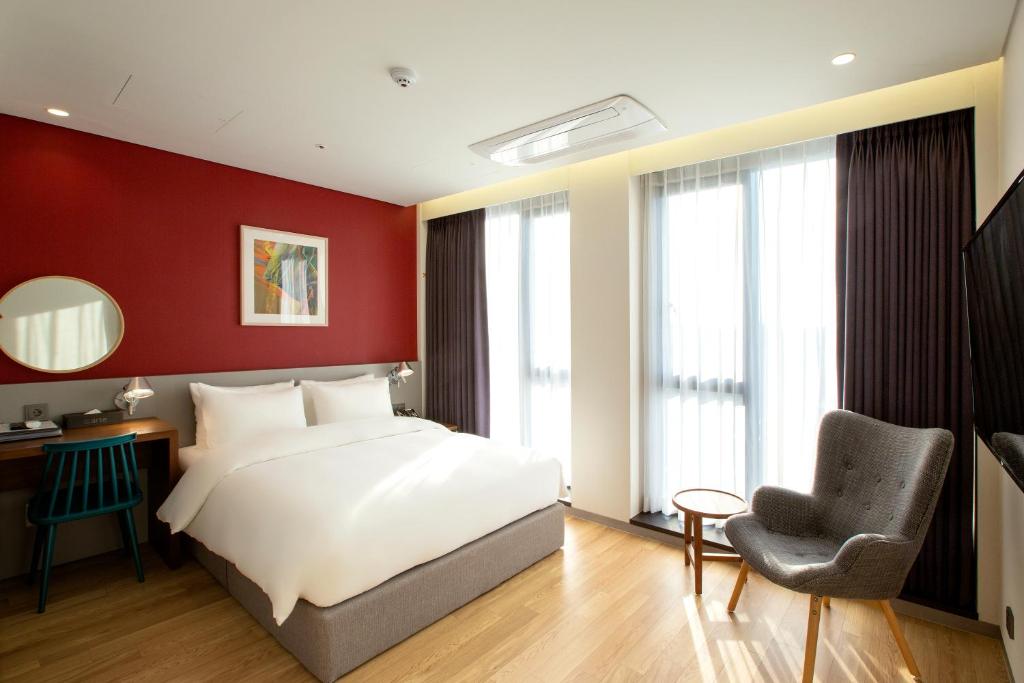 水原市阿尔特酒店的卧室配有白色的床和椅子