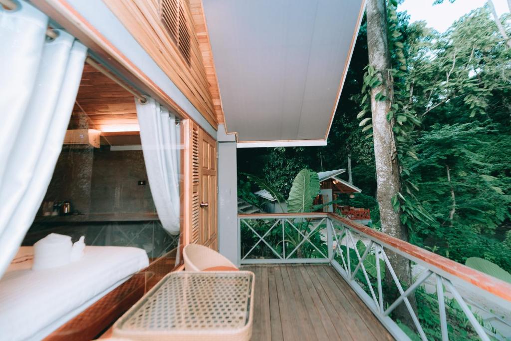 琅勃拉邦Luxury Camp@Green Jungle Park的一个带床和树的户外阳台