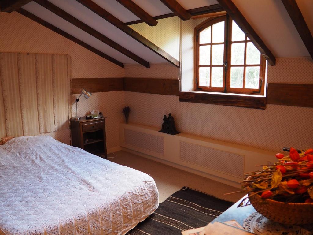AlluyesLa grange的一间卧室设有一张床、一个窗口和一张桌子