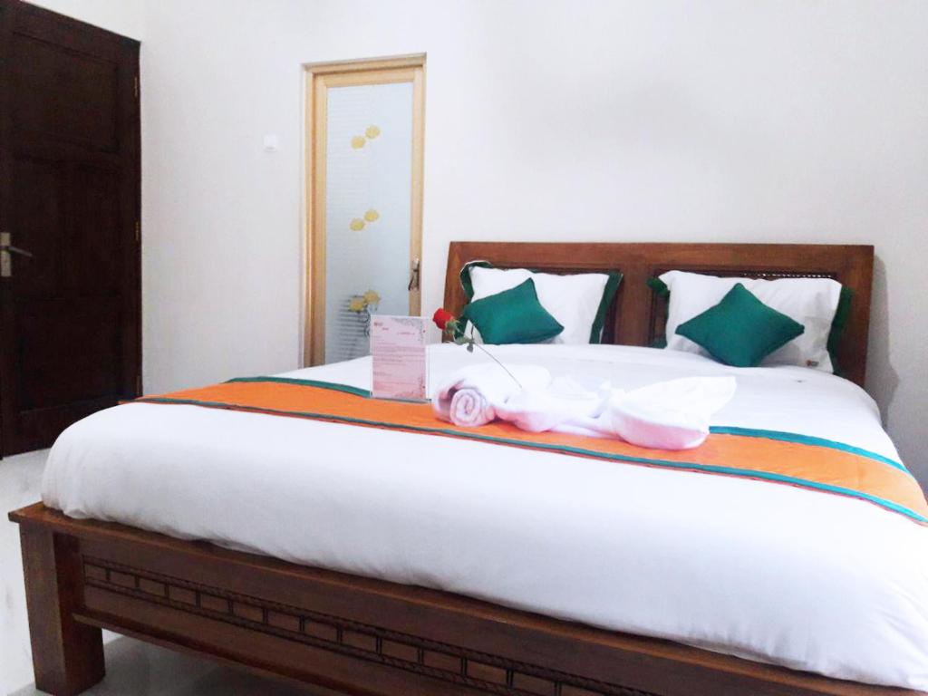 PurbolinggoHomestay Purbalingga Tengah Kota by Simply Homy的一间卧室配有一张床,上面有两个娃娃