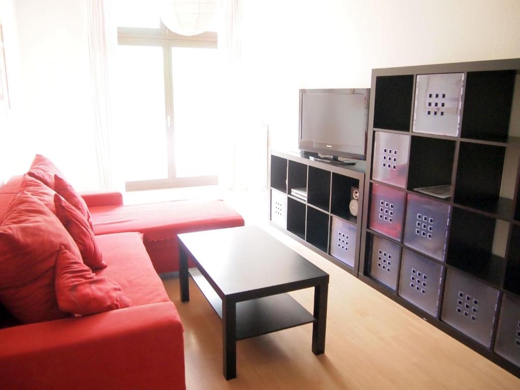 莱茵河畔威尔Apartements im TSB Sportpark的客厅配有红色沙发和电视
