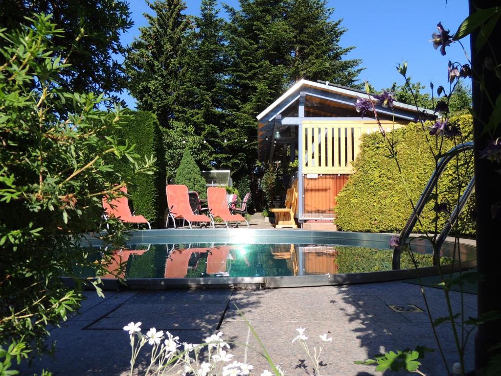 皮尔纳Pension 19的一个带椅子的游泳池和一个背景房子