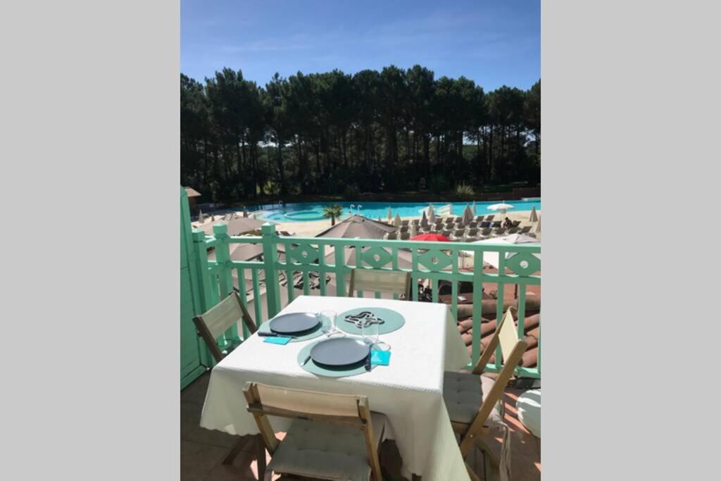 拉卡诺Lumineux, vue piscine, face au Golf, Lacanau Ocean的一个带桌椅的阳台