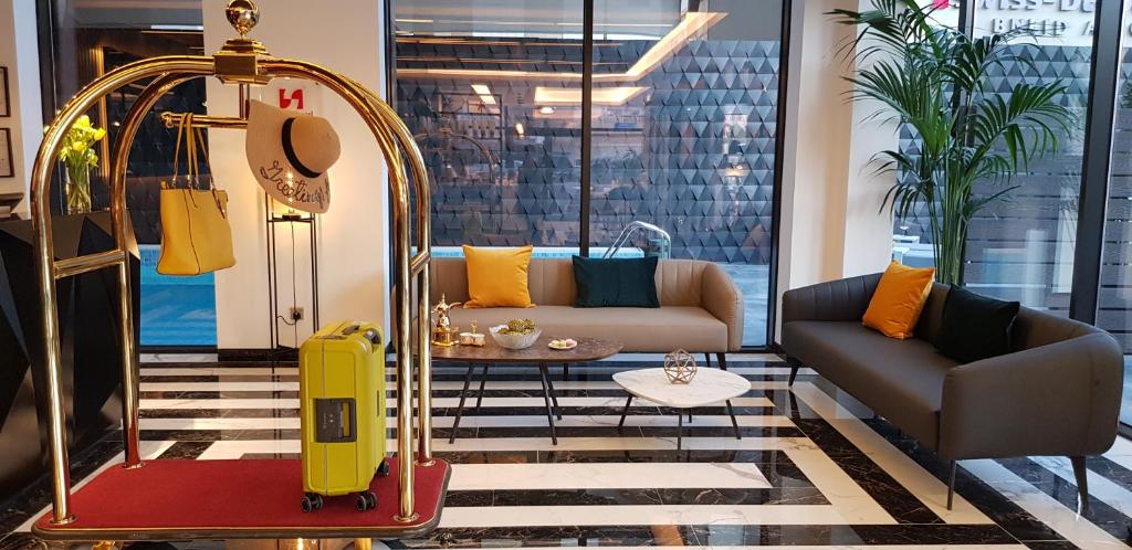 科威特Swiss-Belboutique Bneid Al Gar Kuwait的客厅配有黄色手提箱和沙发