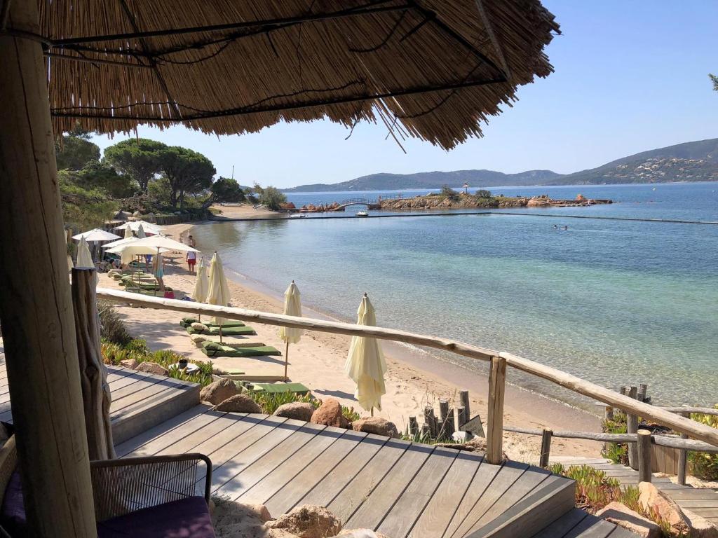 维琪奥港Grand Hôtel De Cala Rossa & Spa Nucca的享有海滩美景,配有遮阳伞和海洋美景。
