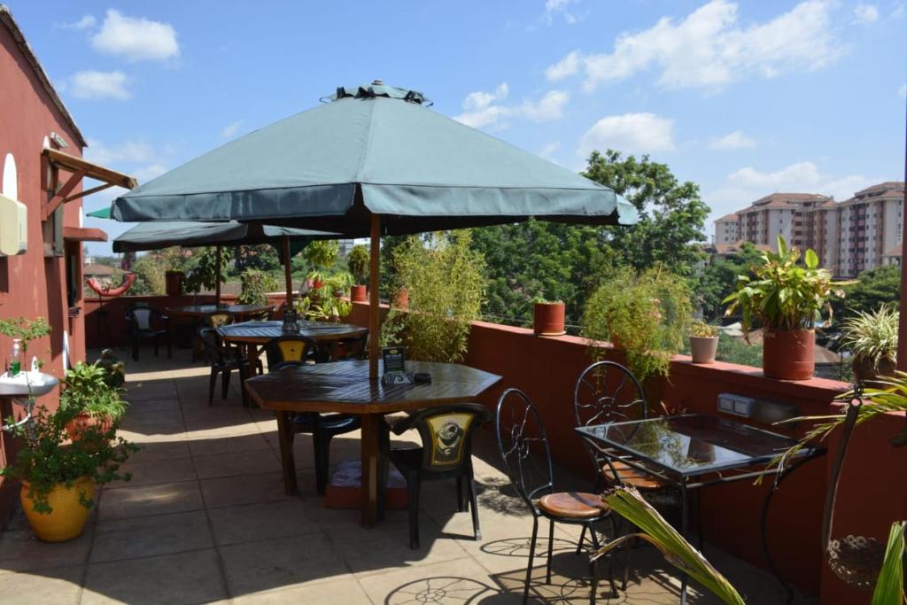 内罗毕科维扎住宿加早餐旅馆的一个带桌椅和遮阳伞的庭院