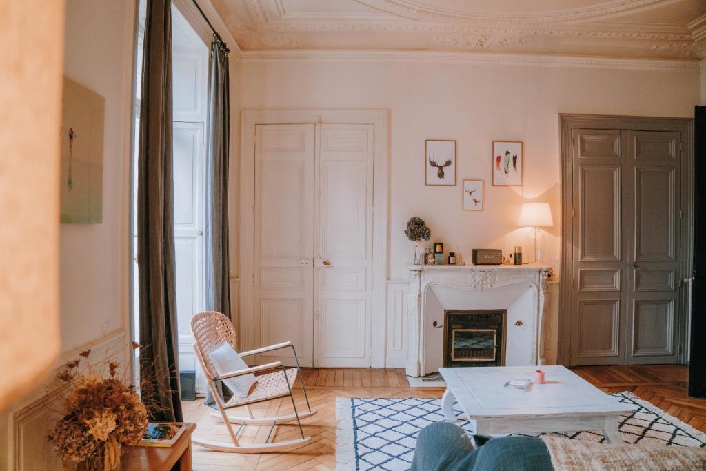 雷恩Chez Angèle的客厅配有桌子和壁炉