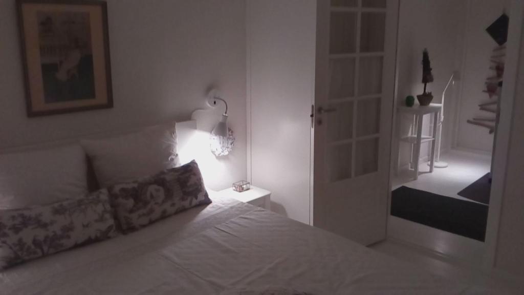 罗斯基勒Hos Anna的卧室配有带灯和门的白色床