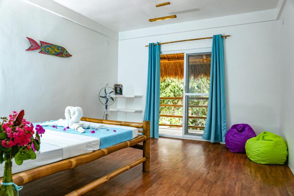 圣维森特Lunazul Guesthouse的一间卧室配有一张带蓝色窗帘的床和一扇窗户