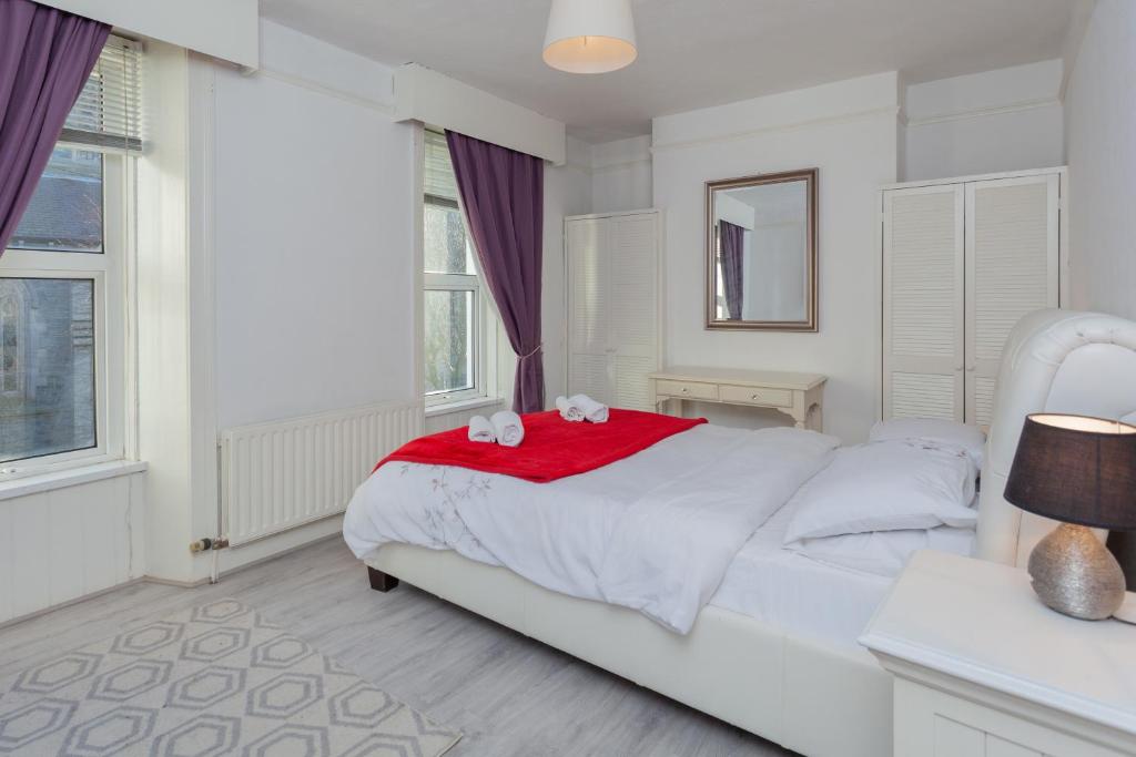 伦敦德里Windsor House的白色卧室配有白色的床和红色毯子
