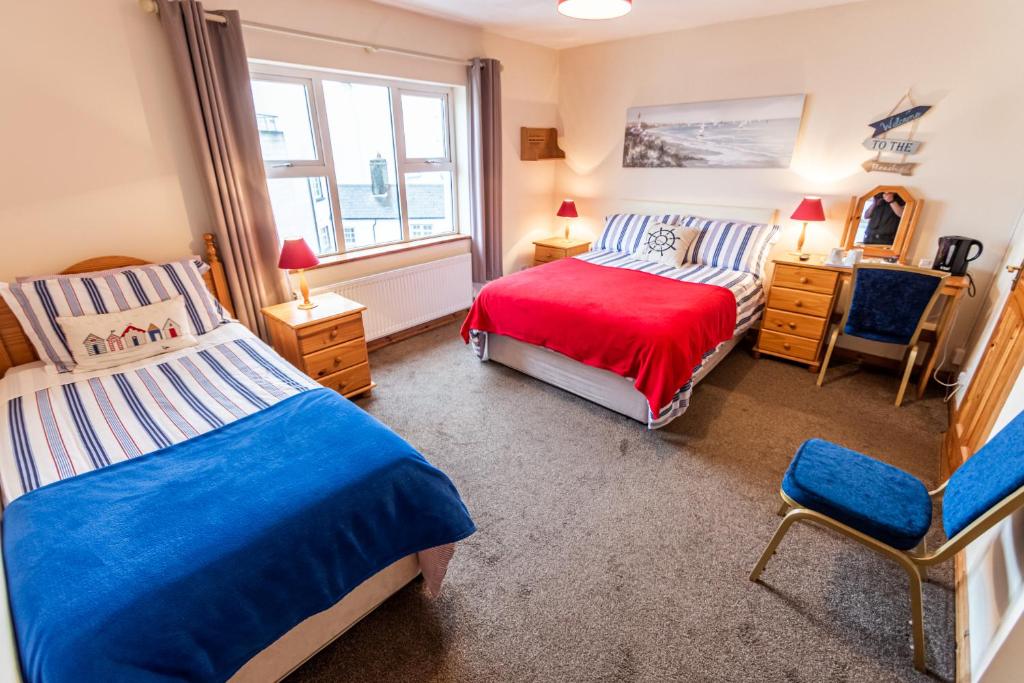 基利贝格斯海风住宿加早餐旅馆的一间卧室设有两张床、一把椅子和一个窗户。