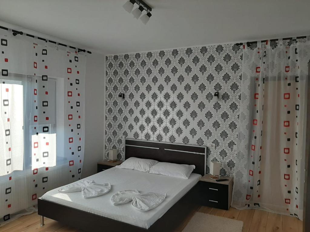 泰基尔吉奥尔Pensiunea Turist的一间卧室配有一张带白色床单和墙壁的床。