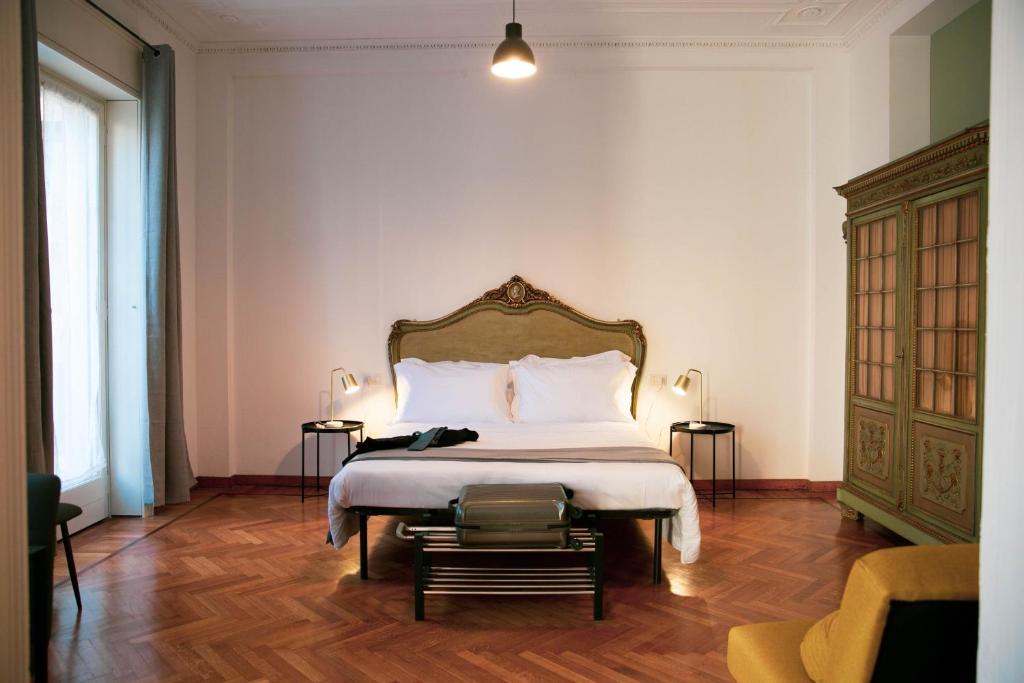 加拉瑞特Palazzo Pasta Malpensa的一间卧室设有一张大床,铺有木地板