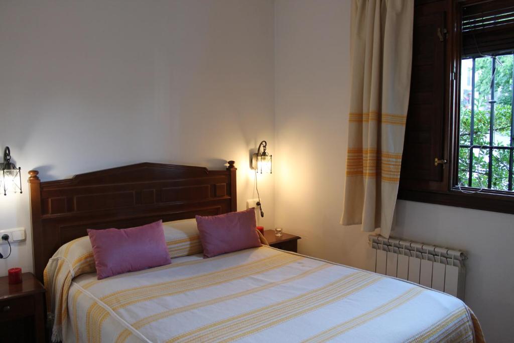 卡皮雷拉Apartamentos Rurales Rosendo: La Canela的一间卧室配有一张带两个紫色枕头的床