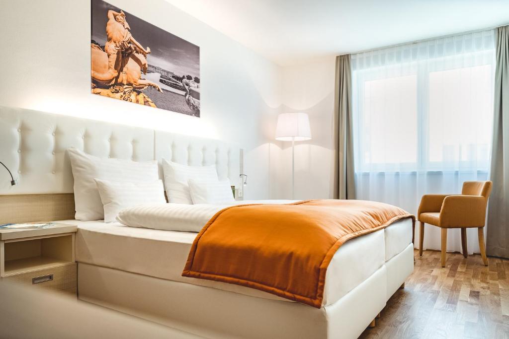 维也纳Oliver Apartments | contactless check-in的白色卧室配有一张带橙色毯子的大床