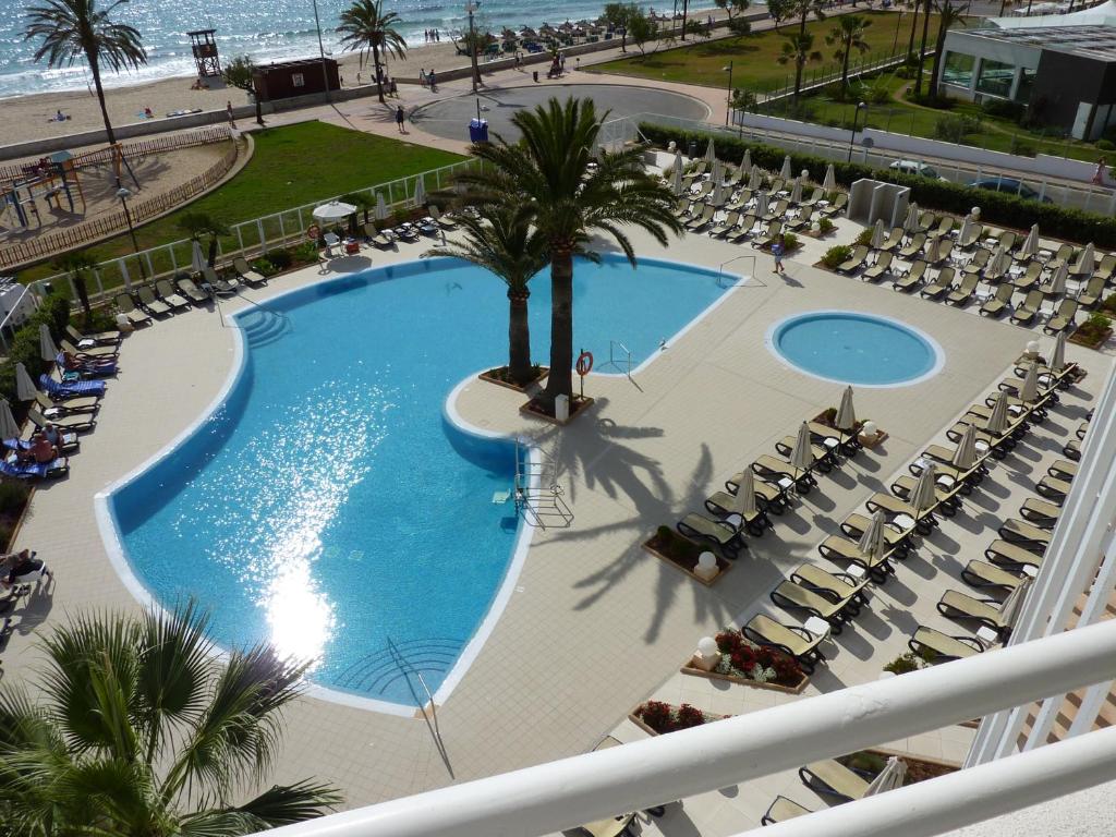 卡拉米洛FeWo Mallorca-ideal - Mercedes的享有带椅子的游泳池和海滩的顶部景色