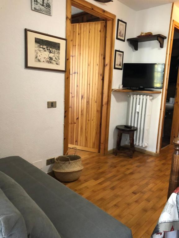 萨奥兹-杜尔克斯APPARTAMENTO MONTAGNA SAUZE D OULX的一间卧室配有一张床,铺有木地板