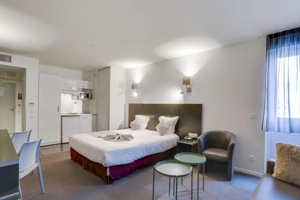 朗吉斯All Suites Appart Hôtel Aéroport Paris Orly – Rungis的酒店客房带一张床、一张桌子和椅子
