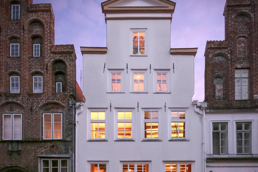 吕贝克哈泽酒店的白色的建筑,窗户上灯火通明