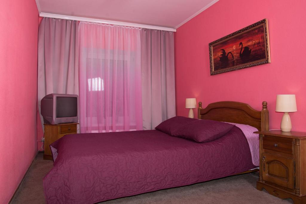 切尔诺夫策诺斯公寓 的粉红色的卧室配有床和电视