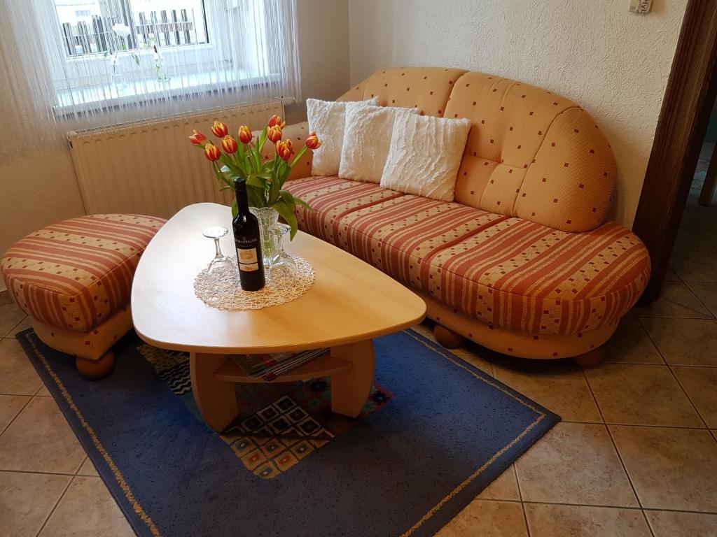 梅森Ferienwohnung Viola的客厅配有沙发和一张带一瓶香槟的桌子
