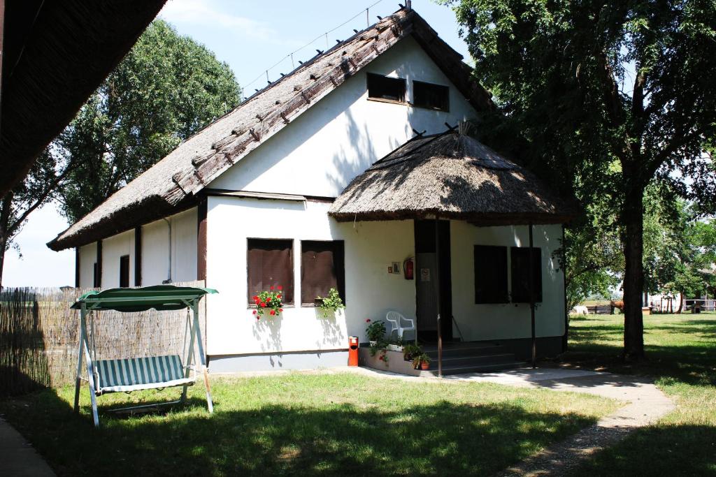 蒂萨菲赖德Patkós Motel的白色的小房子,带有茅草屋顶