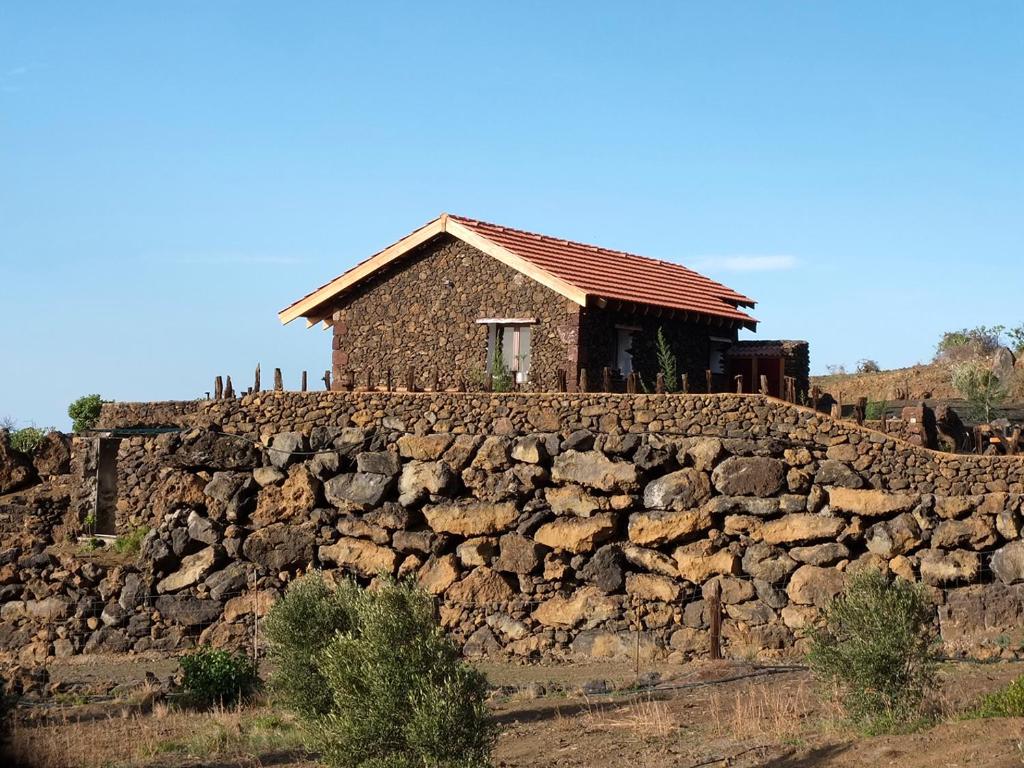 El Pinar del HierroCasa Rural Los Santillos的石墙顶部的房子