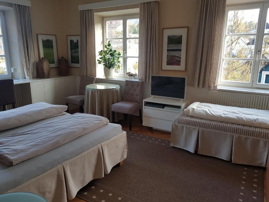 韦耶马克特Gästehaus Grogger的一间卧室设有两张床、一台电视和窗户。