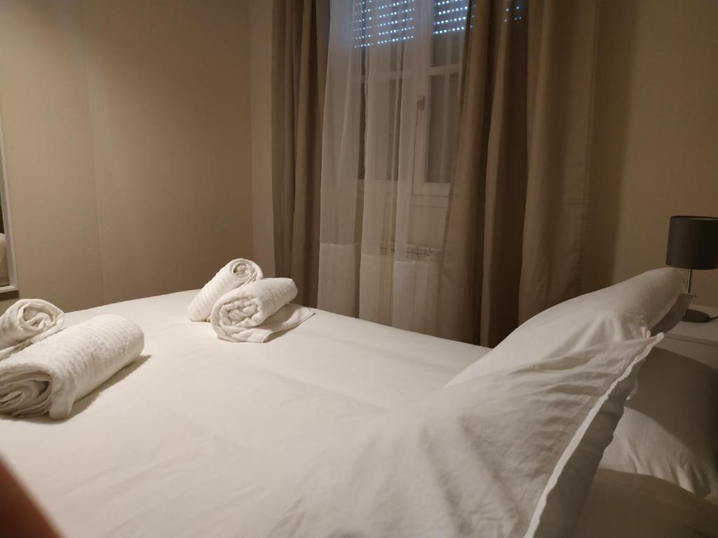 萨莫拉Pilatos的一张带毛巾的白色床,设有窗户