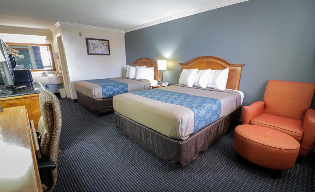 圣安东尼奥University Inn & Suites的酒店客房,配有两张床和椅子