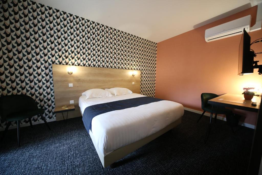 贝桑松Hôtel Fontaine Argent - Centre Ville的酒店客房配有一张床铺、一张桌子和一张书桌。