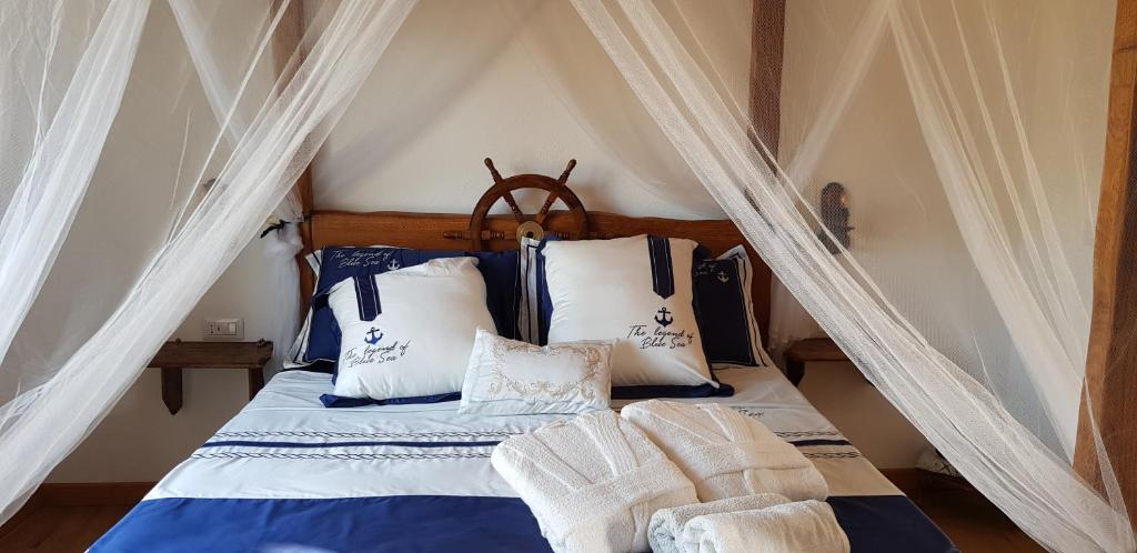 帕劳Tenuta Petra Manna的一间卧室配有天蓬床和蓝色及白色枕头