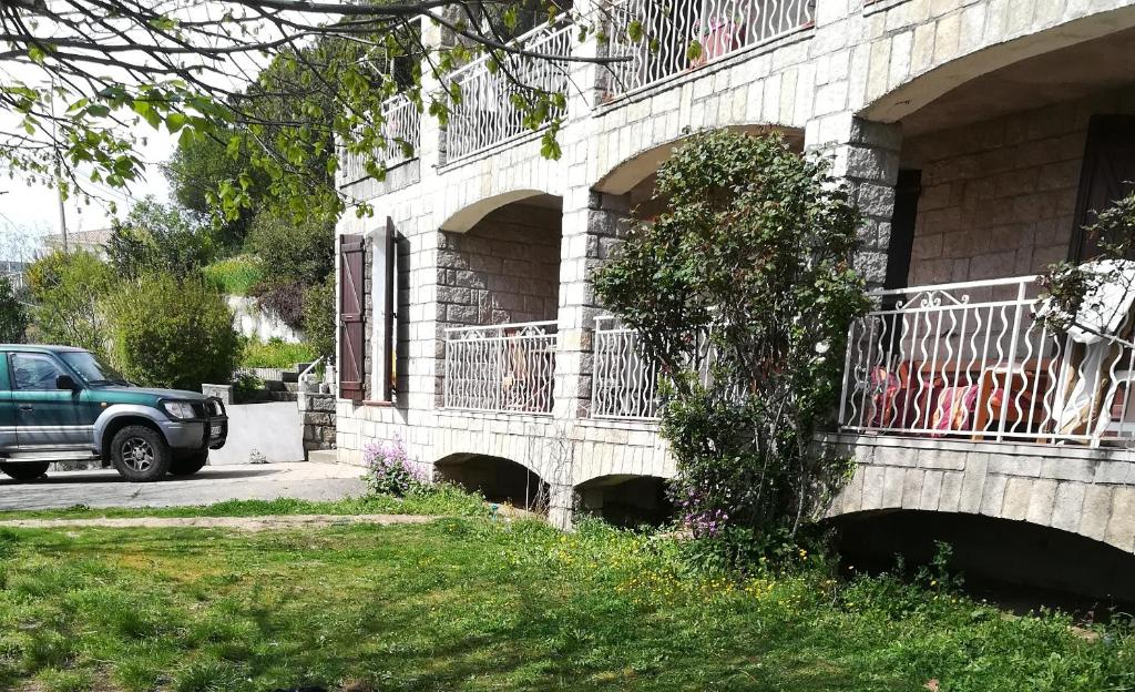 CasalabrivaBelle maison de charme ancien, vue mer et montagne的停在带阳台的建筑旁边的绿色卡车