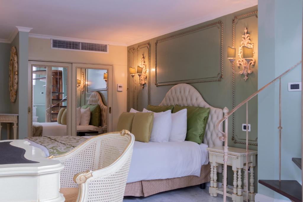 巴拿马城帕尔马别墅精品酒店的卧室配有白色的床和镜子